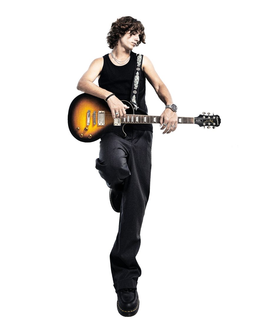 MYLES standing with a sunburst Les Paul, studio