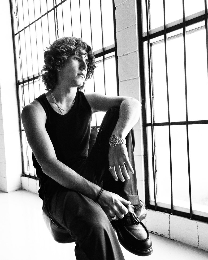 MYLES seated by a barred window, black and white
